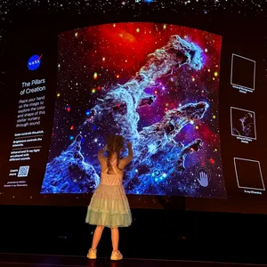 A girl raising her hand up to the sound wall.